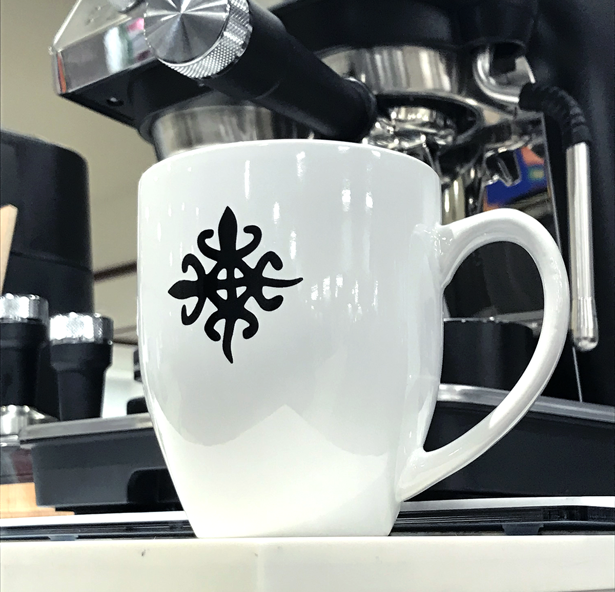 16 oz white coffee mug with black symbol on side