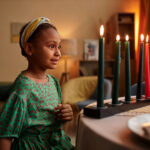 Young girl smiling at Kwanzaa candles